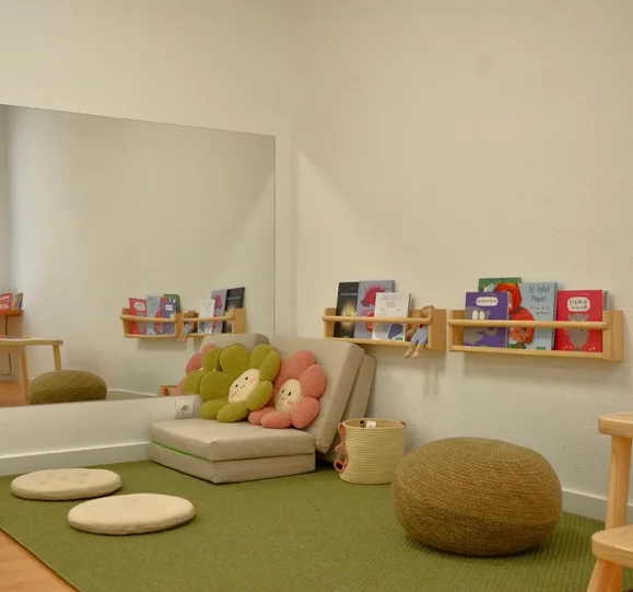 Sala infantil del Centre Quian II amb catifa verda i coixins