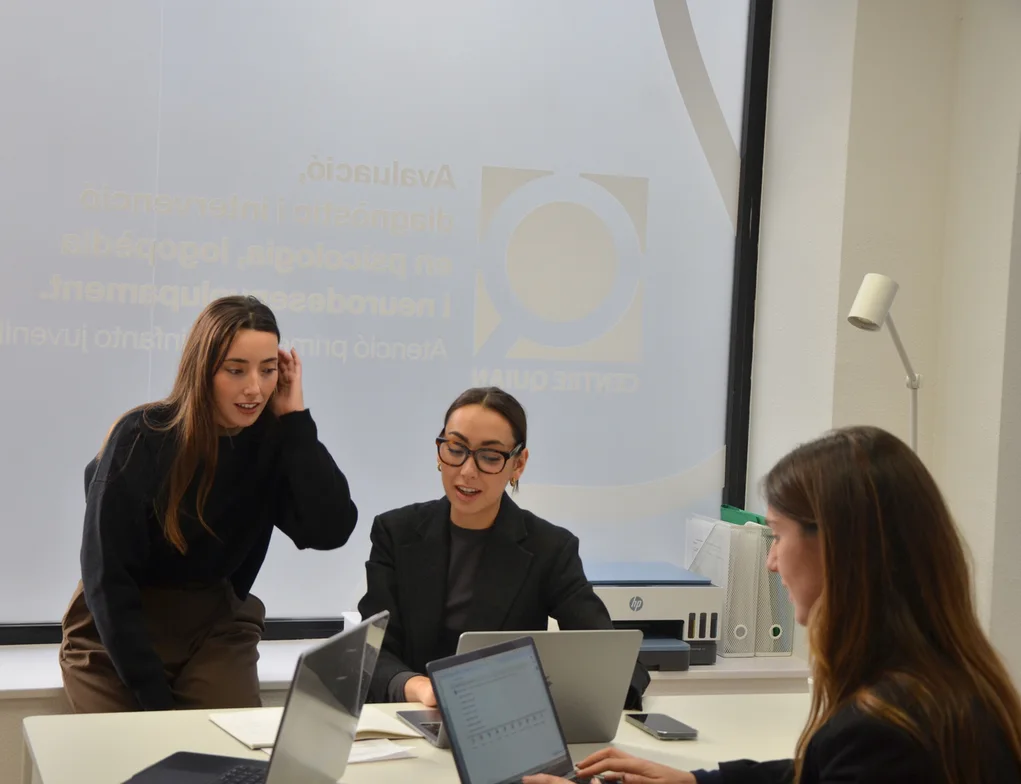 Tres professionals del Centre Quian reunides al voltant d’una taula